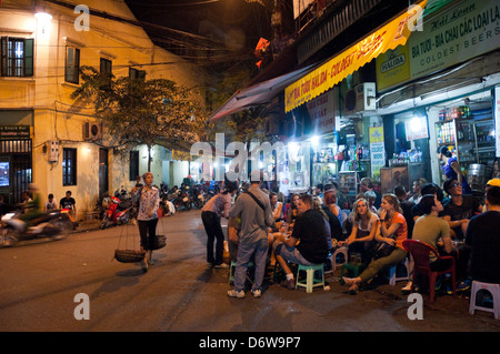 Horizontalen Weitwinkel von vielen Touristen und einheimischen trinken Bier auf der Straße in der Altstadt in Hanoi in der Nacht. Stockfoto