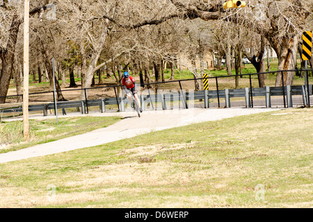 Ein älterer Mann fährt mit dem Fahrrad auf Wanderwegen durch den Norden Canadian River und Overholser See in Oklahoma City, Oklahoma, USA. Stockfoto