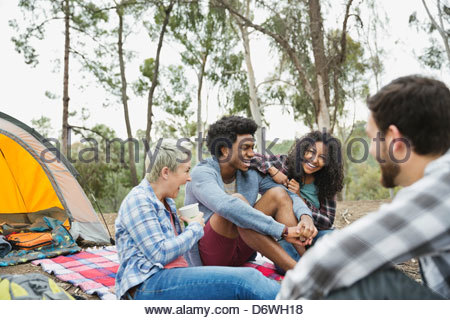 Freunde lachen während Campen zusammen