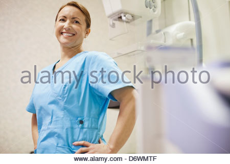 Glücklich zuversichtlich weiblichen Arzt mit Händen auf den Hüften in Klinik