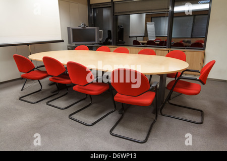 Kleiner Tagungsraum mit Tisch und Stühlen und Projektor Leinwand Stockfoto