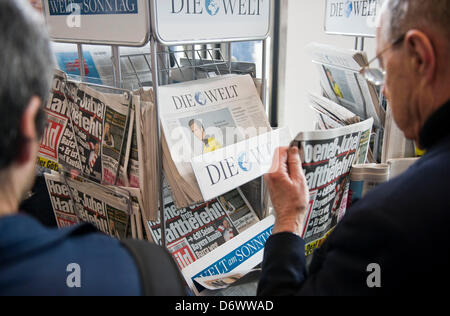 Aktionäre der Axel Springer AG betrachten Zeitungen während der Hauptversammlung das Multimedia-Unternehmen Axel Springer in der Unternehmenszentrale in Berlin, Deutschland, 24. April 2013. Foto: OLE SPATA Stockfoto