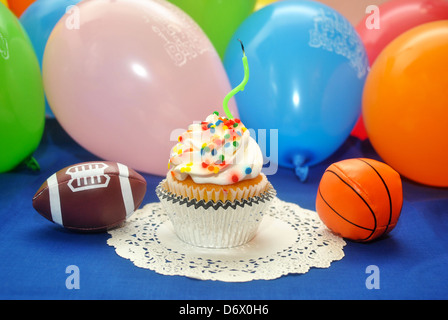 Bithday Cupcake mit 1 Kerze und ein Spielzeug-Fußball und Basketball Stockfoto