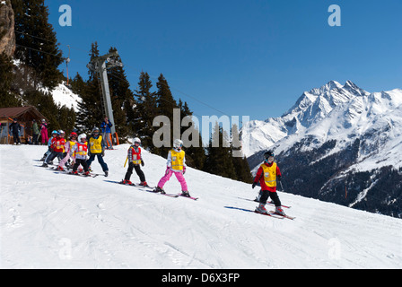 Klasse von kleinen Kindern, die an den hängen oberhalb St. Anton in Tirol Österreich Skifahren lernen Stockfoto