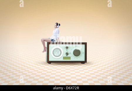 eine Frau trägt Kopfhörer sitzt auf einem radio Stockfoto