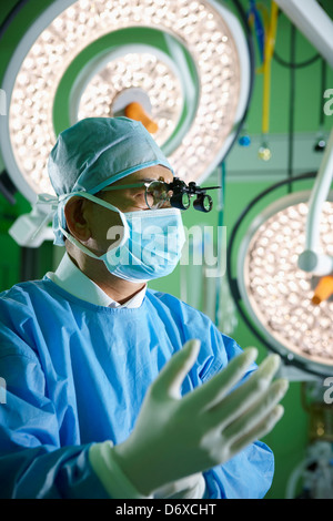 ein Chirurg eine medizinische Schleife tragen Brillen tragen Untersuchungshandschuhe Stockfoto