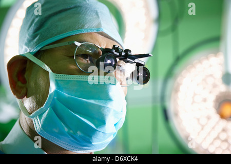 ein Chirurg tragen eine medizinische loop Gläser und medizinischen Maske Stockfoto