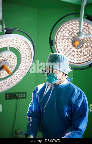 ein Chirurg eine medizinische Schleife tragen Brillen im OP-Saal Stockfoto