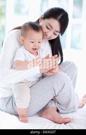Babysitting auf Mutters Schoß Stockfoto