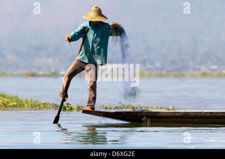 Fischer Bein Rudern und wirft seine Netze am Inle See, Myanmar 8 Stockfoto