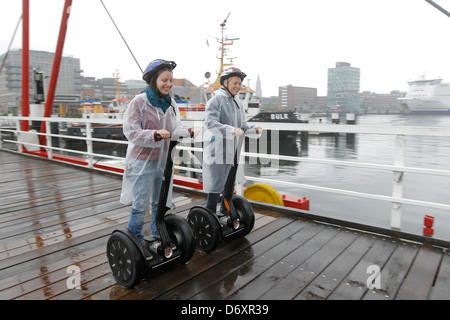 Kiel, Deutschland, zwei Frauen fahren bei starkem Regen auf Segways Stockfoto