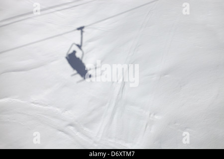 Schatten von einem Sessellift auf den Pisten. Skifahren in Meribel, Frankreich Stockfoto