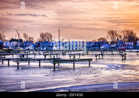 Sonnenuntergang hinter dem schwimmenden Häuser in Bluffer Park Marina in Toronto, Kanada. Winter. Stockfoto