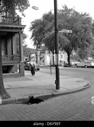 Dieses Foto, das 1960 von Adolph B. Rice Studio aufgenommen wurde, zeigt eine gebrochene Bordsteinkante an der Kreuzung von 34th Street und E. Leigh Street in Richmond, Virginia. Das Bild zeigt ein kleines, aber aussagekräftiges Detail des urbanen Lebens in Richmond's Church Hill Nachbarschaft. Stockfoto