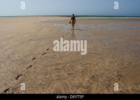 Frau allein zu Fuß am Strand entlang in Fuerteventura Stockfoto