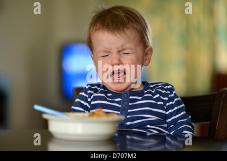 Ein aufgeregt Kleinkind Fütterung selbst eine Schüssel voll Nudeln. Stockfoto