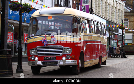 Oldtimer Bus geparkt vor Geschäften Stockfoto