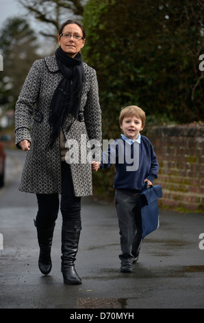 Ein fünf Jahre alter Junge tragen Schuluniform, mit seiner Mutter in die Schule gehen. Stockfoto