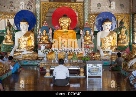 Gläubige beten im Inneren einen Betsaal an der Shwedagon-Pagode, Yangon (Rangoon), Myanmar, (Burma) Stockfoto