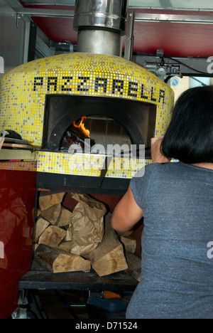 Köchin, Einblasen von Luft in PazzaRella Holz befeuert Ofen Pizza Einzelhandel Lebensmittel Truck Vancouver Victory Square Hastings street Stockfoto