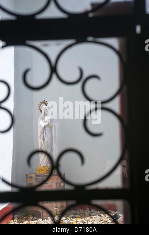 Schmiedeeisen-Fenster-Bildschirm mit Statue der Madonna im Hintergrund auf die pilgernde Kirche auf Monserrate Hügel, Bogota, Kolumbien Stockfoto