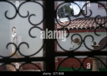 Schmiedeeisen-Fenster-Bildschirm mit Statue der Madonna im Hintergrund auf die pilgernde Kirche auf Monserrate Hügel, Bogota, Kolumbien Stockfoto