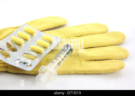 Blister und Spritzen auf die gelbe Handschuhe. Stockfoto