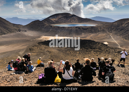 Wanderer ruht auf dem höchsten Punkt auf gerade Rauch aufsteigt aus dem Krater Te Maari, Mount Tongariro Tongariro Crossing Stockfoto