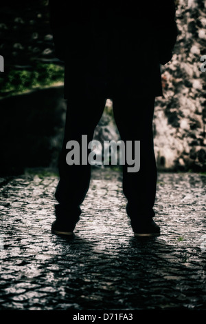 Beine eines Mannes in einer dunklen Gasse Stockfoto