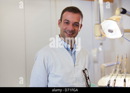 Zahnärztliche Versorgung und Hygiene, Porträt von Erwachsenen kaukasischen Zahnarzt bei der Arbeit und in die Kamera Lächeln Stockfoto