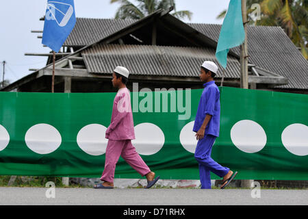 26. April 2013 - Dungun, Terengganu, Malaysia - muslimische Jungen gehen vorbei an malaysischen Oppositionspartei, Pan-malaysische islamische Partei (PAS) Banner in Dungun, rund 300 Kilometer nordöstlich von Kuala Lumpur. Malaysia gehen zu den Wahlen am 5. Mai. Insgesamt 222 parlamentarischen und 505 Zustand Sitze werden angefochten werden. (Kredit-Bild: © Najjua Zulkefli/ZUMAPRESS.com) Stockfoto