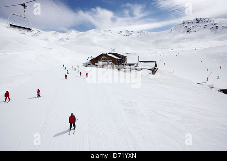 Les Chalets du Thorens mit Skifahrer in den Vordergrund & Hintergrund. Art-Foto aus einem Skiurlaub in den französischen Alpen zu reisen. Stockfoto