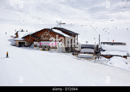 Les Chalets du Thorens mit Skifahrer im Hintergrund. Typische Reise Art Foto aus einem Skiurlaub in den französischen Alpen. Stockfoto