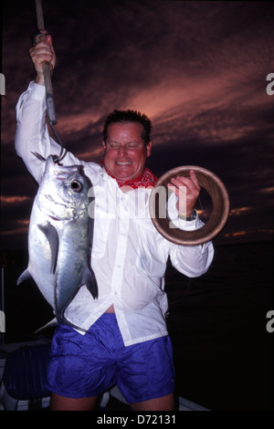 Ein Fischer mit einem Jack Crevalle (Caranx Hippos) gefangen in einer Hand-Zeile am Turneffe Atoll Belize Stockfoto