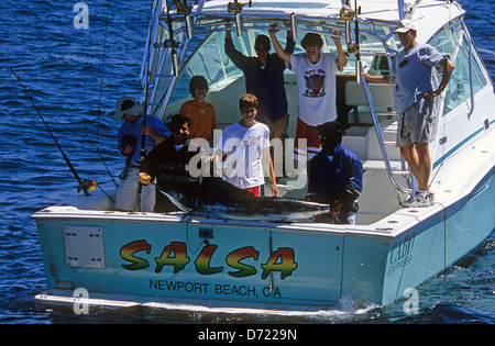 Fischer Landung einen gestreifter Marlin (Tetrapturus Audax) auf ein Sportangeln Boot in der Nähe von Cabo San Lucas Baja California Mexiko Stockfoto