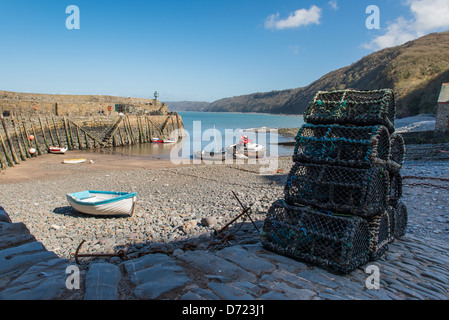 Clovelly, Nord-Devon, England. Die Hafenmauer und Strand mit Hummer Töpfe stapeln sich im Vordergrund. Stockfoto