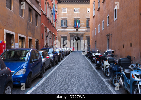 Einem gepflasterten Seitenstraße nahe dem Vatikan zeigt Autos geparkt auf der einen Seite und Mopeds geparkt auf der anderen in Rom, Italien Stockfoto