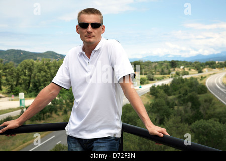 Hübscher blonder Mann auf malerische Autobahn Hintergrund in Frankreich Stockfoto