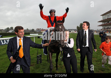 Danedream mit Andrasch Strong, Inhaber Heiko Volz und Trainer Peter Schiergen nach dem Gewinn der Longines Grand Prix Baden Stockfoto