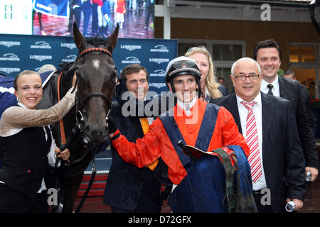 Danedream mit Andrasch Strong, Helmut und Heiko Volz und Trainer Peter Schiergen nach dem Gewinn der Longines Grand Prix Baden Stockfoto