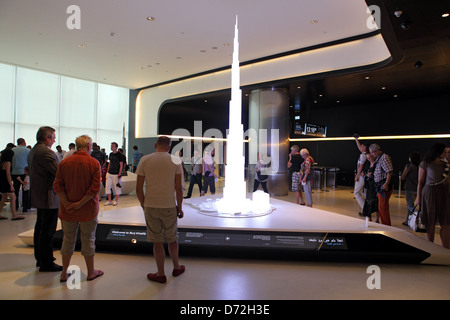 Dubai, Vereinigte Arabische Emirate, Menschen sind mit einem Modell des Burj Khalifa konfrontiert. Stockfoto