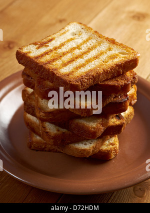 Stapeln Sie Scheiben geröstetes Brot zum Frühstück. Nahaufnahme von getoastetem Weißbrot in Scheiben Stockfoto