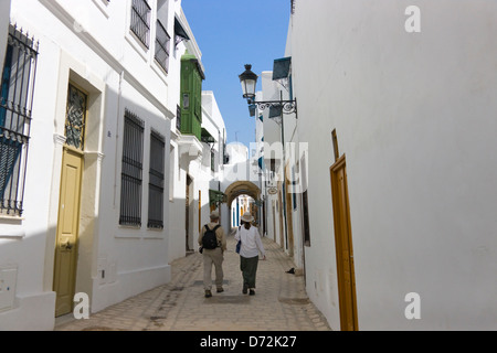 Touristen gehen auf der Straße mit traditionellen Häusern, Sidi Bou Said, Tunis, Tunesien Stockfoto