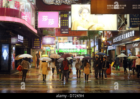 Hong Kong, China, Menschen in Regen in Causeway Bay District bei Nacht Stockfoto