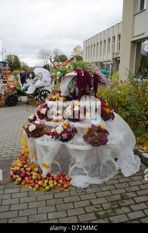 herbstliche Blumenschmuck lässt Obst Äpfel in outdoor Herbst Ernte-Festival und künstliche Ehepaar im Wagen. Stockfoto