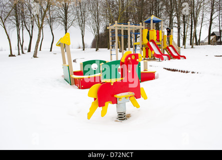 leere bunten Spielplatz umgeben von Schnee im Winter. Stockfoto