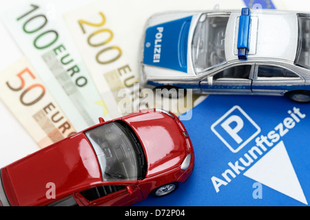 Miniatur-Auto, Banknoten und Parkscheibe, höhere Strafen für Falschparker Stockfoto