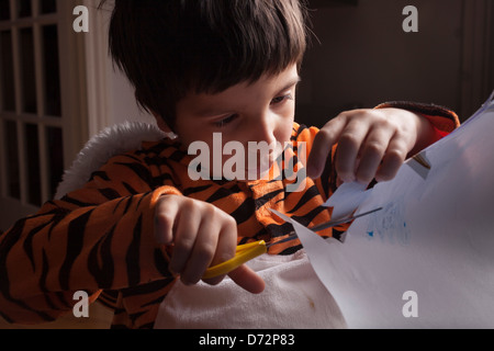 kleiner Junge in Tiger Kostüm Schneiden von Papier, Bücher Welt Tag, London, UK Stockfoto