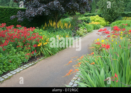 Pflasterweg in blühenden englischen Garten Stockfoto