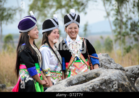 Drei junge Hmong Frauen in traditionellen Kostümen für das Hmong Neujahr posieren für ein Foto unter die alten steinernen Gläser von Plain of Jars, Laos. Stockfoto